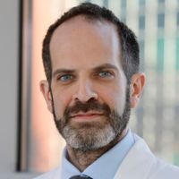 Portrait of a researcher in a lab coat with a confident expression.