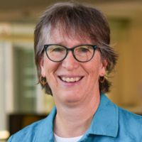 Portrait of a researcher smiling in a professional setting.