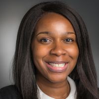 Portrait of a smiling researcher with long dark hair and a white collar.