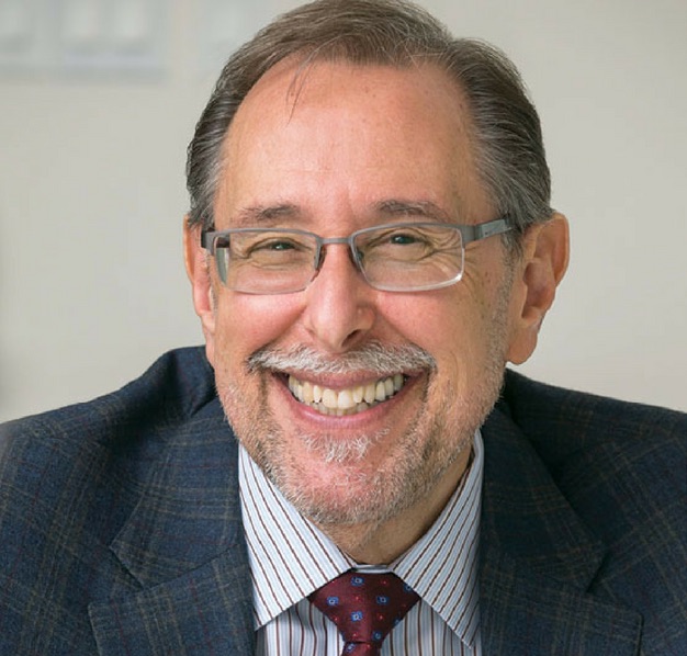 Portrait of a smiling man in glasses and a suit.